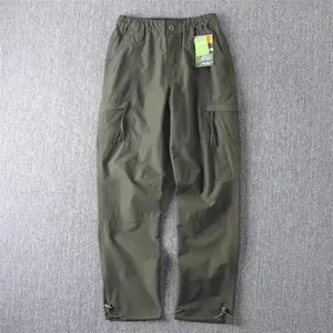 Detailed view of men's olive green cargo pants with multi-pocket design and drawstring hem