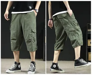 Detail of olive green men's loose fit cargo 3/4 length pants with multiple pockets