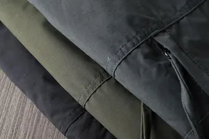 Macro detail of waterproof outdoor pants showing durable fabric texture and zipper pocket.