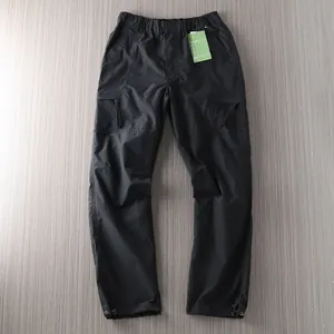 Detailed full view of black waterproof outdoor cargo pants featuring multiple utility pockets
