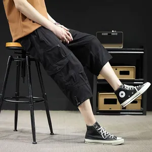 Men's black cargo shorts featuring multiple pockets and drawstring hem in a relaxed casual fit