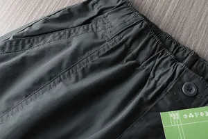 Detail view of waterproof outdoor hiking pants with elastic waistband and pocket stitching.