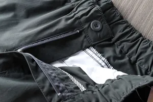 Close-up detail of zipper and elastic waist on men's outdoor quick-dry hiking pants.
