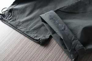 Close-up detail of the adjustable drawstring cuffs on men's waterproof outdoor hiking pants