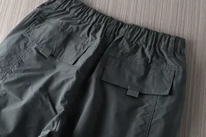 Close-up of elastic waistband and large back pockets on men's outdoor cargo pants.