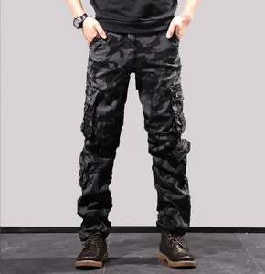 Detailed view of men's durable black camouflage multi-pocket cargo pants outdoors