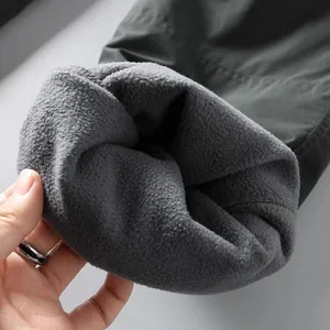 Detail shot of thick grey fleece lining in men's winter outdoor cargo work pants