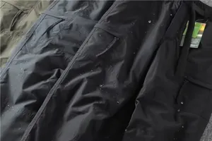 Close-up of waterproof quick-dry fabric on men's multi-pocket cargo pants in black and grey.