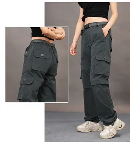 Detailed view of grey quick-dry cargo pants with multiple tactical pockets and belt