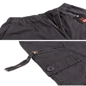 Detailed macro view of the waistband and side cargo pocket of dark grey pants