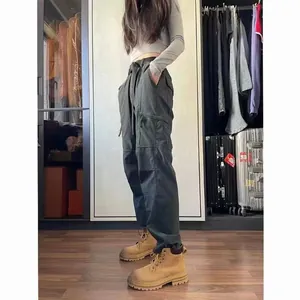 Woman wearing dark techwear cargo pants and tan hiking boots in a dressing room