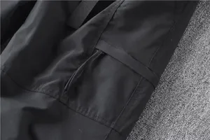 Close-up view of black quick-dry cargo pants showing a durable pocket flap and stitching