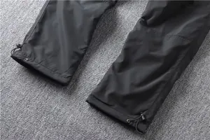 Detailed view of adjustable drawstring cuffs on mens black quick-dry cargo pants.