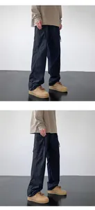 Detail view of black outdoor quick-dry techwear pants in a minimalist studio setting