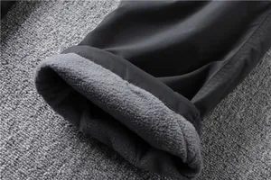 Detail of warm fleece lining in black cargo pants for men's outdoor winter wear