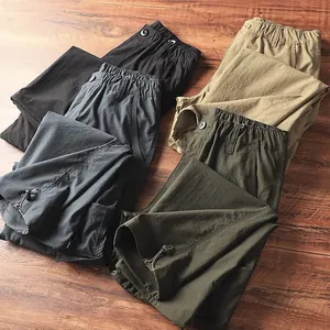 Vista dettagliata di pantaloni cargo da uomo ad asciugatura rapida in quattro colori su legno.