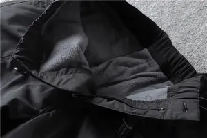 Detailed macro view showing warm grey fleece lining and waistband on black cargo pants