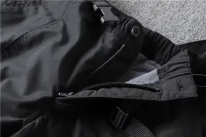 Detailed view of black cargo pants featuring a sturdy zipper and warm grey fleece lining