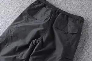Detailed view of the dark grey cargo pants' back flap pockets and elastic waistband.