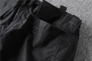 Close-up detail of multi-pocket cargo pants featuring durable Velcro fasteners and stitching