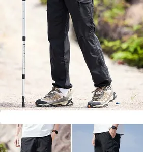 Detailansicht der schwarzen schnelltrocknenden Wanderhose mit Trekkingstock im Freien