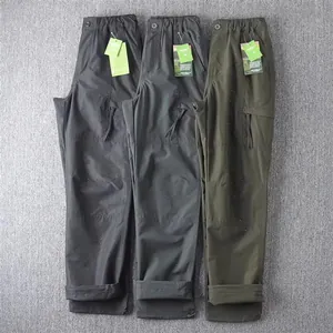 Detail of waterproof men's tactical cargo pants in black, grey, and olive green.