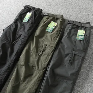 Detail view showing three colors of outdoor softshell cargo pants with belts and tags