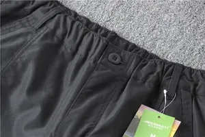 Close-up detail of elastic waistband and button on black men's cargo pants