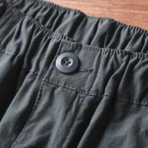 Dettaglio dell'elastico in vita e del bottone di pantaloni cargo ad asciugatura rapida