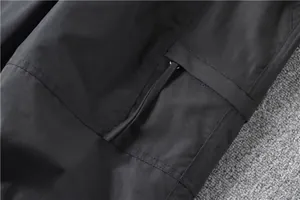 Close-up detail showing pocket flap and precise stitching on black men's cargo pants.