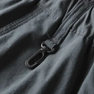 Primo piano del robusto moschettone in metallo sui pantaloni cargo outdoor ad asciugatura rapida