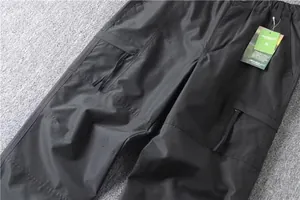 Detail view of men's multi-pocket cargo pants showing high-quality fabric texture