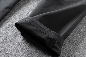 Close-up detail of the durable hem and stitching on black straight-leg cargo pants.