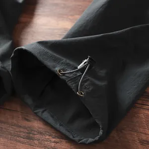 Dettaglio ravvicinato dell'orlo con coulisse regolabile dei pantaloni cargo da uomo outdoor