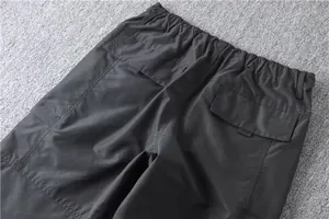 Detail of waist and rear pockets on men's thermal cargo pants in dark grey
