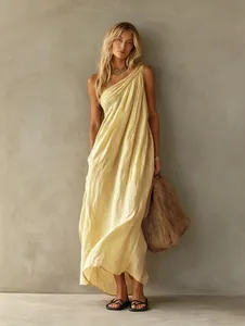 Detail view of the elegant one-shoulder pleated yellow maxi dress and drape