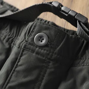 Dettaglio della cintura dei pantaloni da trekking con bottone e fibbia a scatto.