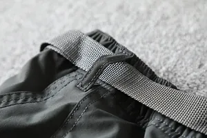 Macro view of the adjustable waistband and belt on outdoor softshell cargo pants