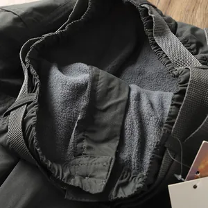 Primo piano dettagliato della calda fodera in pile grigio dei pantaloni tattici