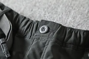 Close-up detail of elastic waistband and button on men's outdoor cargo pants