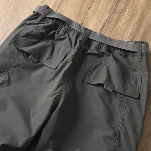 Dettaglio della vita dei pantaloni da trekking grigi con cintura e tasche a patta