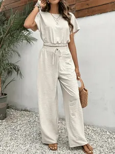 Tweedelige beige outfit met textuur bestaande uit crop top en wijde broek.