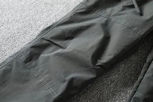 Close-up of durable windproof fabric and double stitching on outdoor softshell pants.