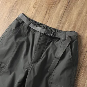 Dettaglio della vita dei pantaloni da trekking con cintura regolabile in tela grigia