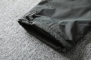 Close-up of the adjustable drawstring toggle hem on waterproof outdoor softshell pants