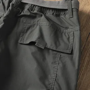Dettaglio della tasca posteriore e della cintura sui pantaloni cargo grigi da uomo outdoor