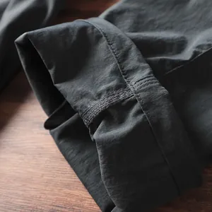Dettaglio del tessuto tecnico ad asciugatura rapida e cuciture robuste sui pantaloni cargo