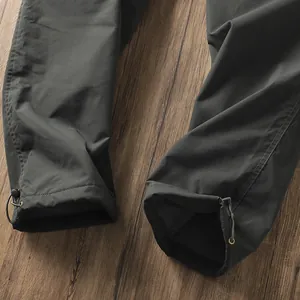 Dettaglio dei polsini con cordoncino regolabile su pantaloni da trekking impermeabili