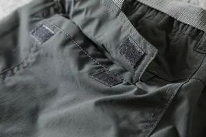 Close-up detail of Velcro pocket closure on men's waterproof outdoor softshell cargo pants