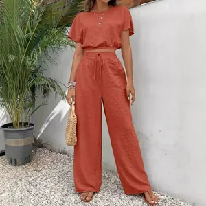 Elegant tweedelig setje in gebrand oranje met crop top en wijde broek voor dames